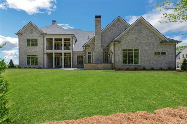 back of house featuring a lawn and a balcony