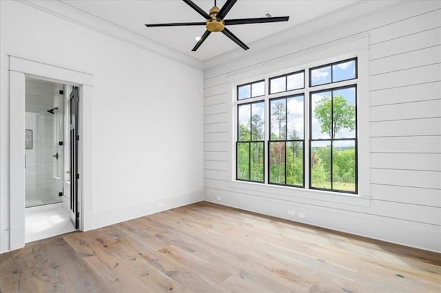 unfurnished room with ceiling fan, light wood-type flooring, and crown molding