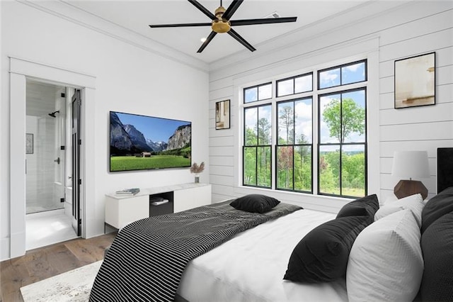 bedroom with wood-type flooring, ensuite bathroom, ceiling fan, and ornamental molding