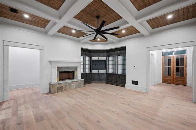 unfurnished living room with a stone fireplace, ceiling fan, beamed ceiling, and coffered ceiling