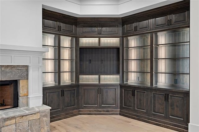 mudroom with light hardwood / wood-style floors and a fireplace