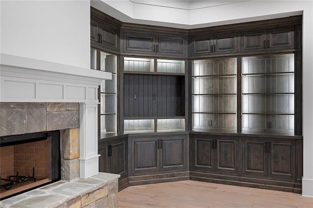 interior space with light wood-type flooring and a stone fireplace