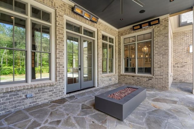 view of patio with ceiling fan, an outdoor fire pit, and french doors