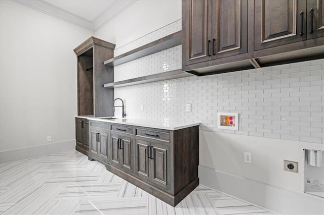 kitchen featuring dark brown cabinetry, tasteful backsplash, crown molding, and sink