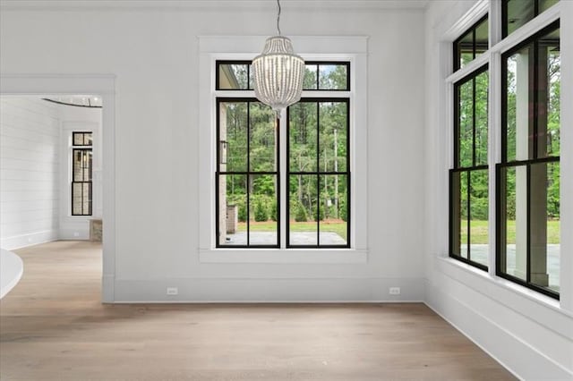 interior space with light hardwood / wood-style floors and a notable chandelier