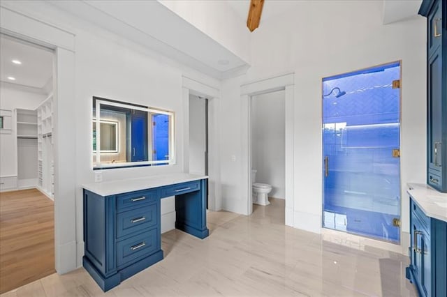 bathroom featuring vanity, beamed ceiling, an enclosed shower, and toilet