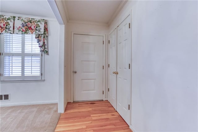 entryway with light wood-type flooring and ornamental molding