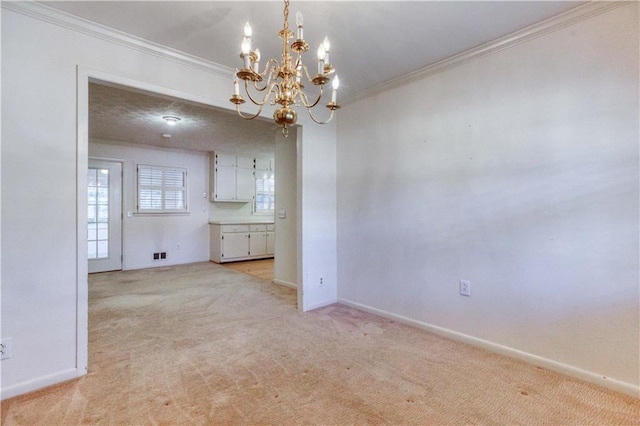 carpeted spare room featuring ornamental molding and an inviting chandelier