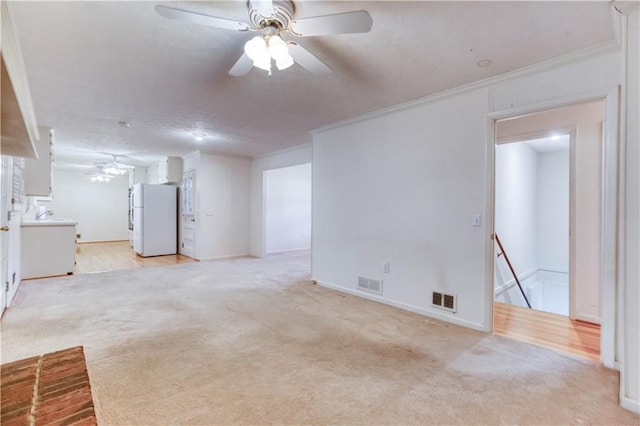 interior space with light carpet, crown molding, and ceiling fan