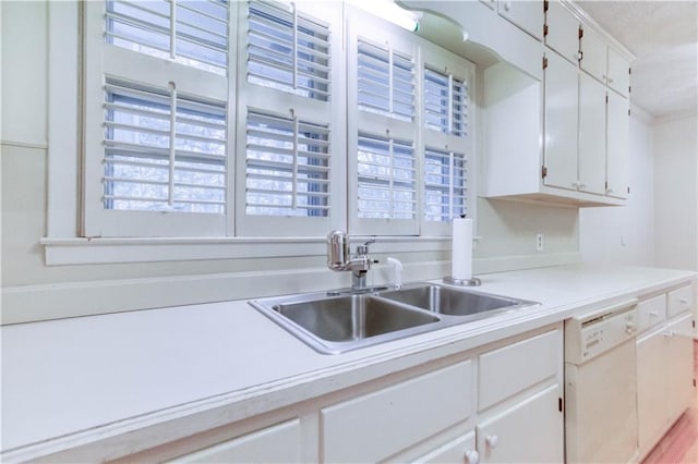 kitchen featuring white cabinets, dishwasher, and sink