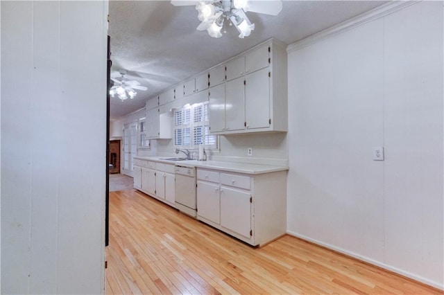 kitchen featuring white cabinets, ornamental molding, sink, dishwasher, and light hardwood / wood-style floors