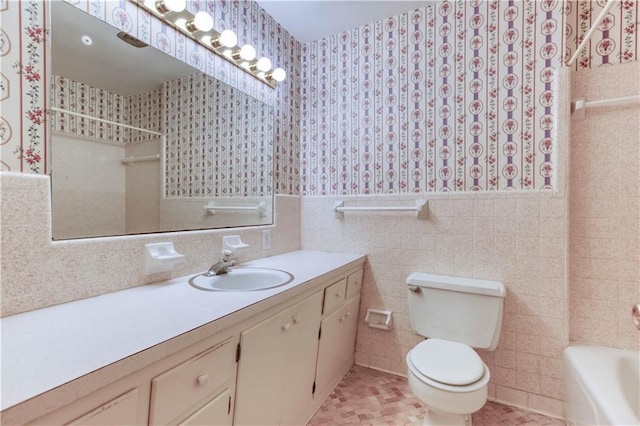 full bathroom featuring washtub / shower combination, vanity, tile walls, tile patterned flooring, and toilet