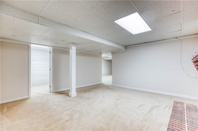 basement featuring carpet flooring and a drop ceiling