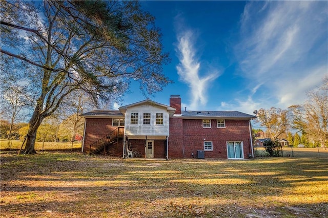 rear view of property with a lawn and central AC