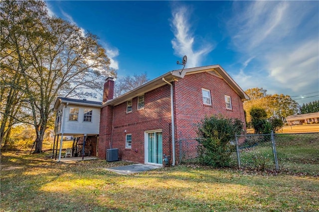 back of property with a lawn and cooling unit