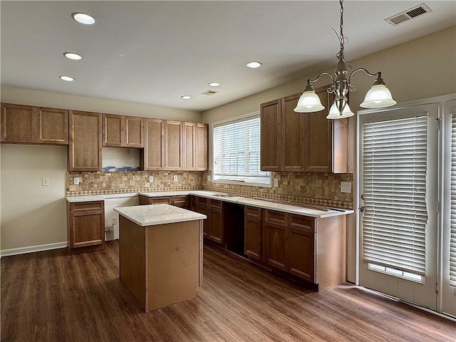 kitchen featuring decorative backsplash, dark hardwood / wood-style floors, a center island, and hanging light fixtures