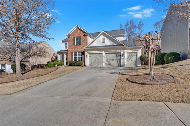 traditional-style home with brick siding, a garage, and driveway