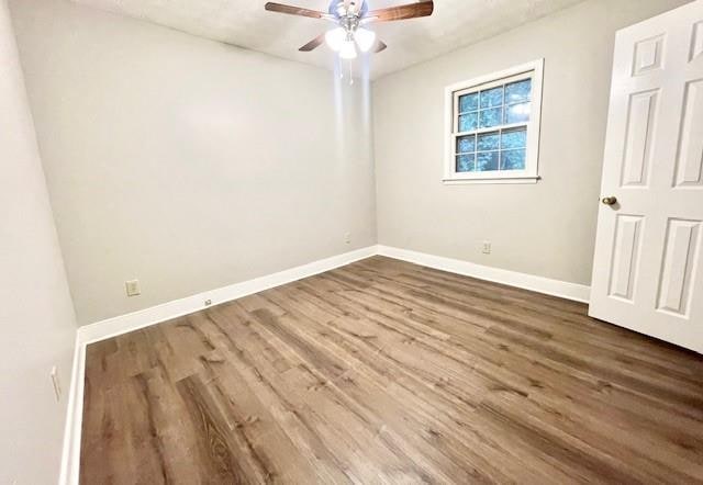 spare room featuring hardwood / wood-style flooring and ceiling fan