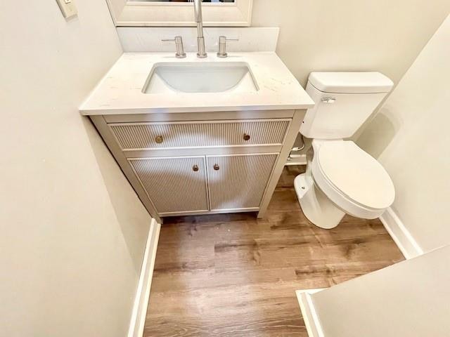 bathroom featuring hardwood / wood-style flooring, vanity, and toilet