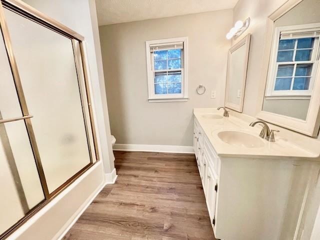 full bathroom with shower / bath combination with glass door, vanity, toilet, a textured ceiling, and hardwood / wood-style floors