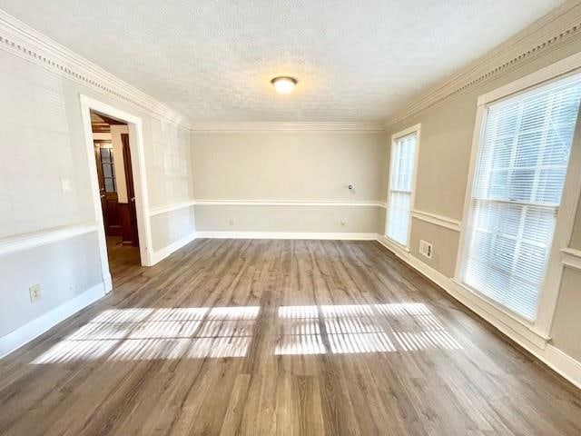 spare room with ornamental molding, hardwood / wood-style flooring, and a textured ceiling