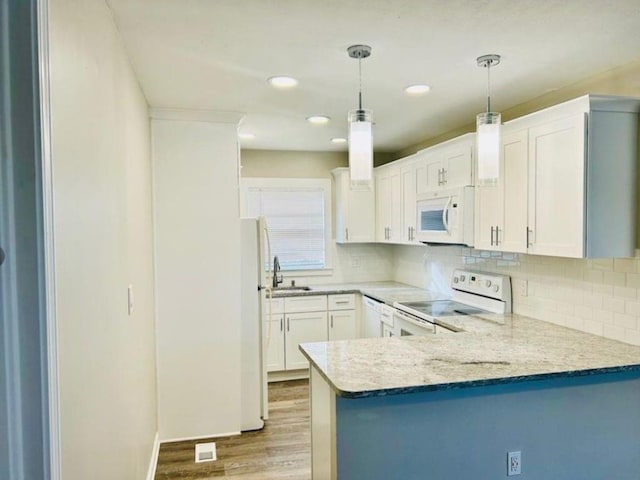 kitchen featuring white cabinets, hanging light fixtures, kitchen peninsula, white appliances, and light hardwood / wood-style flooring