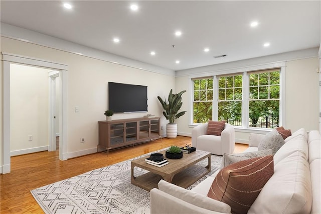 living area with recessed lighting, baseboards, and wood finished floors