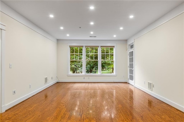 unfurnished room with recessed lighting, visible vents, baseboards, and wood finished floors