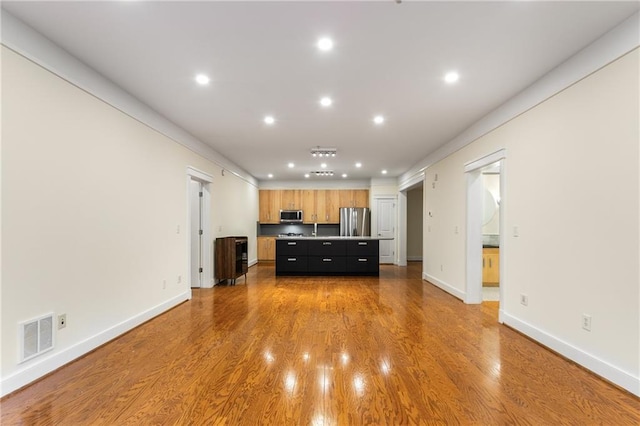 unfurnished living room featuring recessed lighting, wood finished floors, visible vents, and baseboards