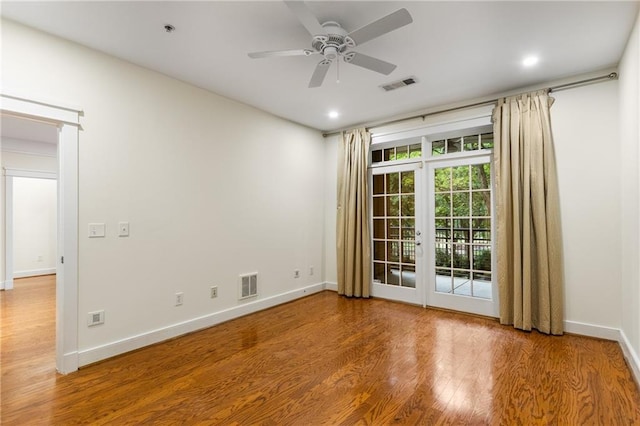 unfurnished room with visible vents, baseboards, a ceiling fan, and wood finished floors