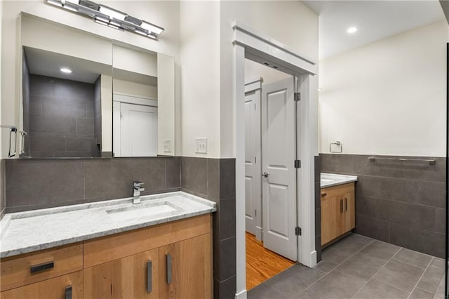 bathroom with vanity, tile walls, tile patterned flooring, and wainscoting