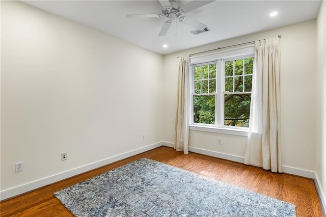 spare room featuring wood finished floors, visible vents, baseboards, recessed lighting, and ceiling fan