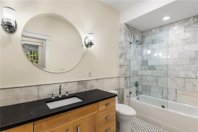 full bath featuring vanity, a wainscoted wall, shower / bath combination, tile walls, and toilet