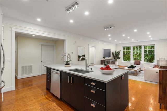 kitchen featuring visible vents, a sink, stainless steel dishwasher, open floor plan, and light countertops