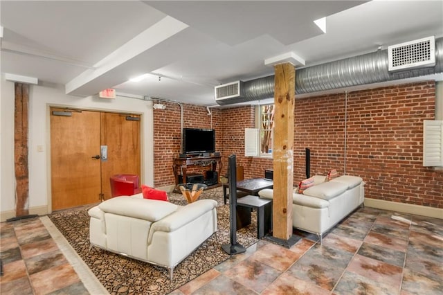 living area with visible vents, brick wall, and baseboards