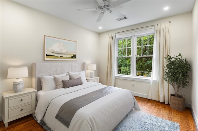 bedroom with recessed lighting, wood finished floors, visible vents, and baseboards