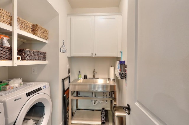 clothes washing area with cabinet space, independent washer and dryer, and a sink