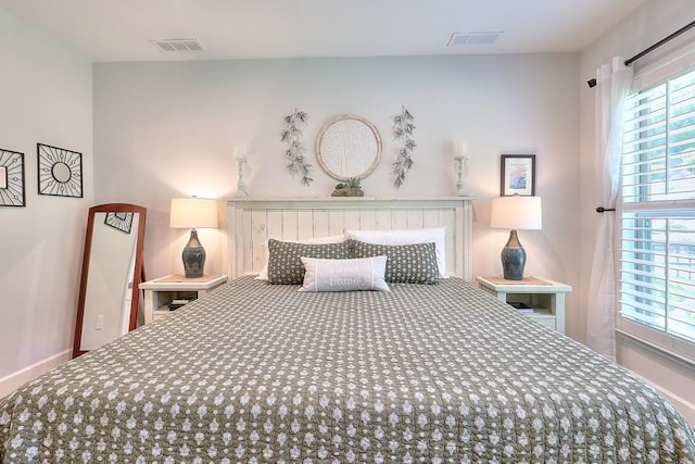 bedroom featuring baseboards and visible vents