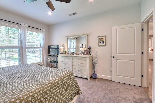 bedroom with a ceiling fan, light colored carpet, visible vents, and baseboards