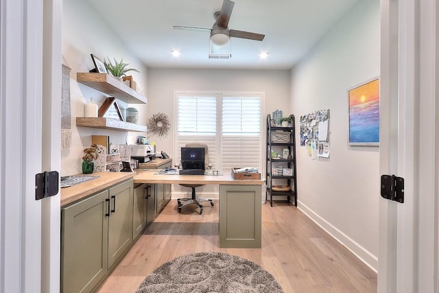 office space featuring a ceiling fan, baseboards, visible vents, and light wood finished floors