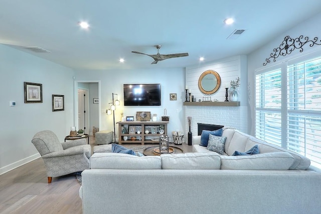 living area featuring recessed lighting, a brick fireplace, ceiling fan, wood finished floors, and baseboards