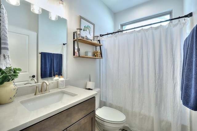 full bath with curtained shower, vanity, and toilet