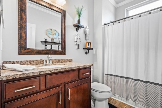 bathroom featuring toilet, vanity, and crown molding