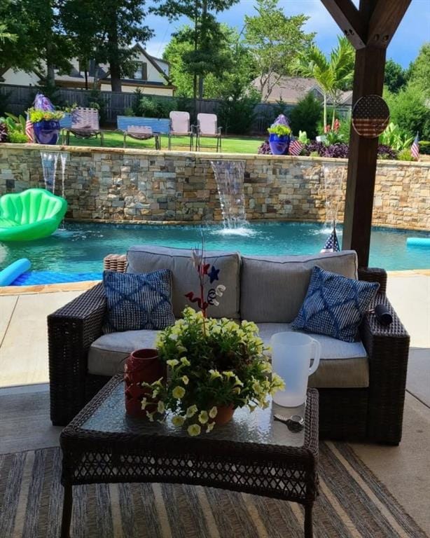 view of pool with an outdoor living space and pool water feature