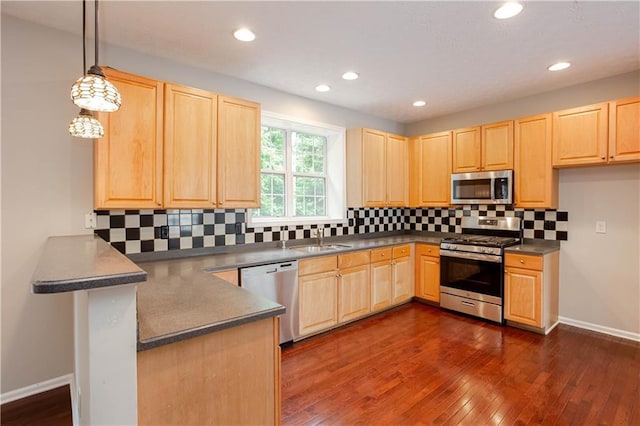 kitchen with appliances with stainless steel finishes, tasteful backsplash, dark hardwood / wood-style floors, light brown cabinetry, and hanging light fixtures