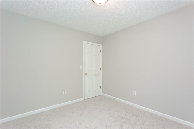 carpeted spare room featuring a textured ceiling