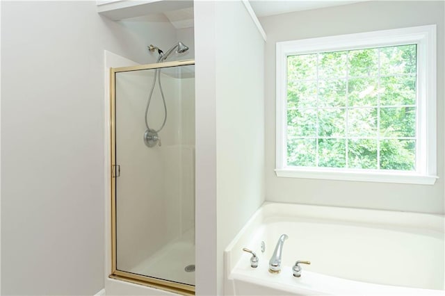 bathroom featuring plenty of natural light and independent shower and bath