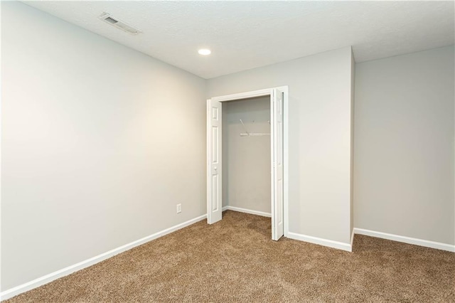 unfurnished bedroom with a closet and dark colored carpet