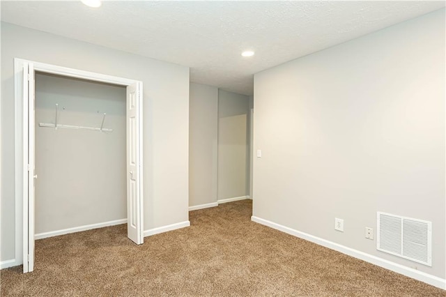 unfurnished bedroom featuring a closet and dark colored carpet