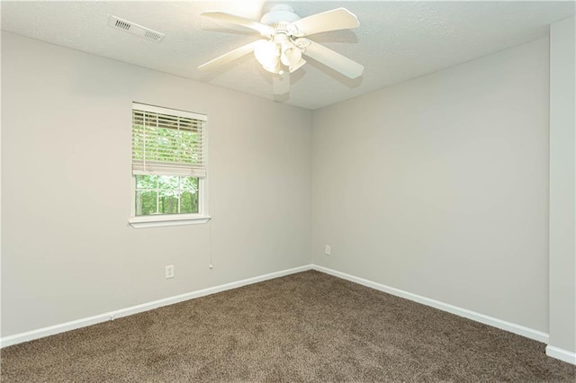 spare room featuring dark carpet and ceiling fan